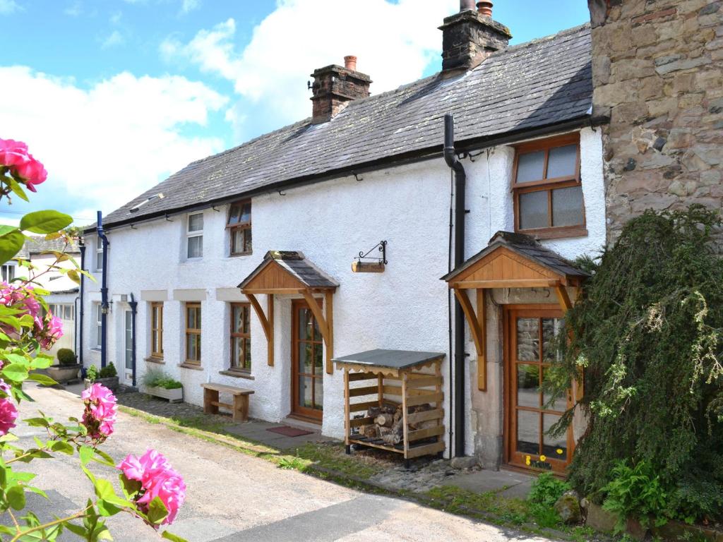 an old white house with wooden doors and windows at Windy Nook in Pooley Bridge