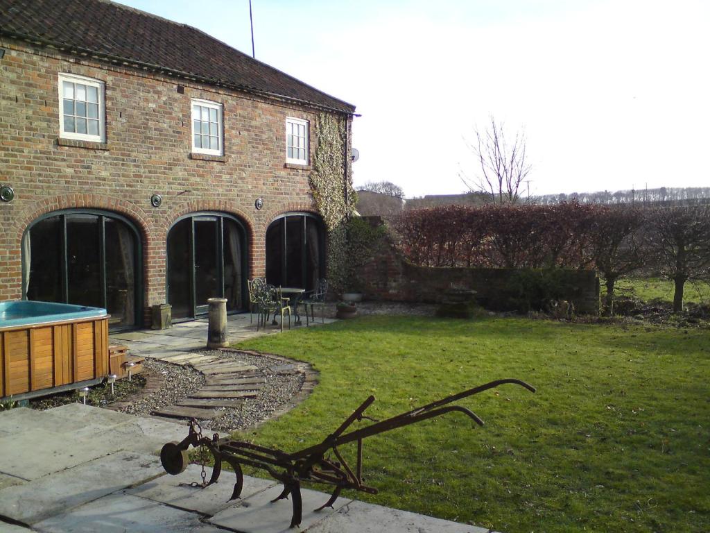 a yard with a bench in front of a building at Spring Farm Barn in Grindale