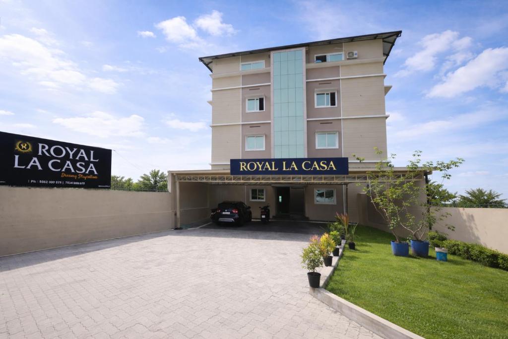 a building with a parking lot in front of it at Royal La Casa in Cochin