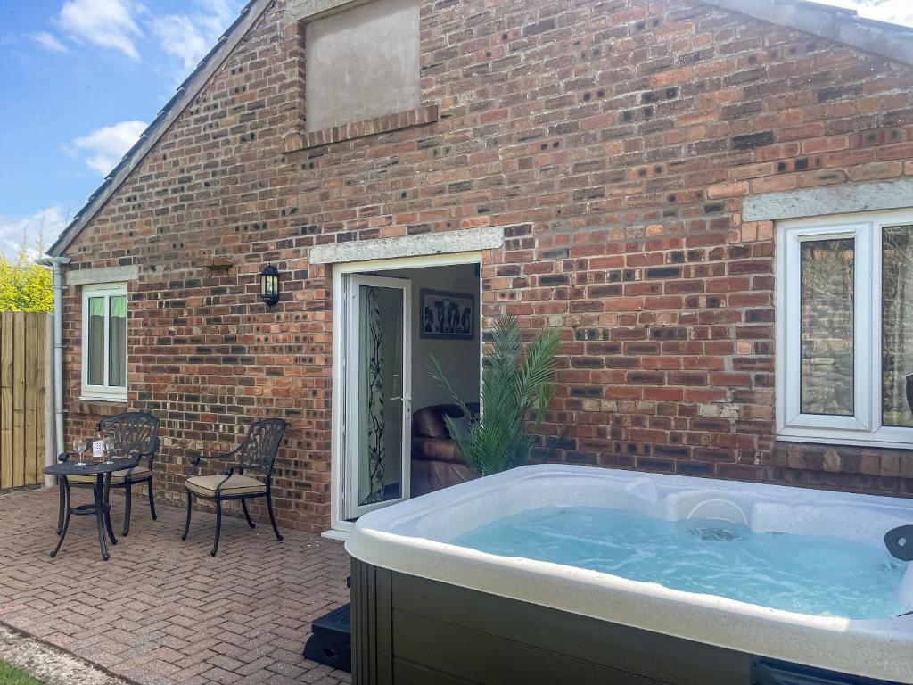 a hot tub in front of a brick building at Milking Parlour - Uk48911 in Allonby