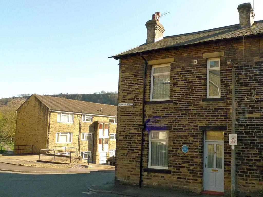 an old brick building on the side of a street at Ted's House in Mytholmroyd