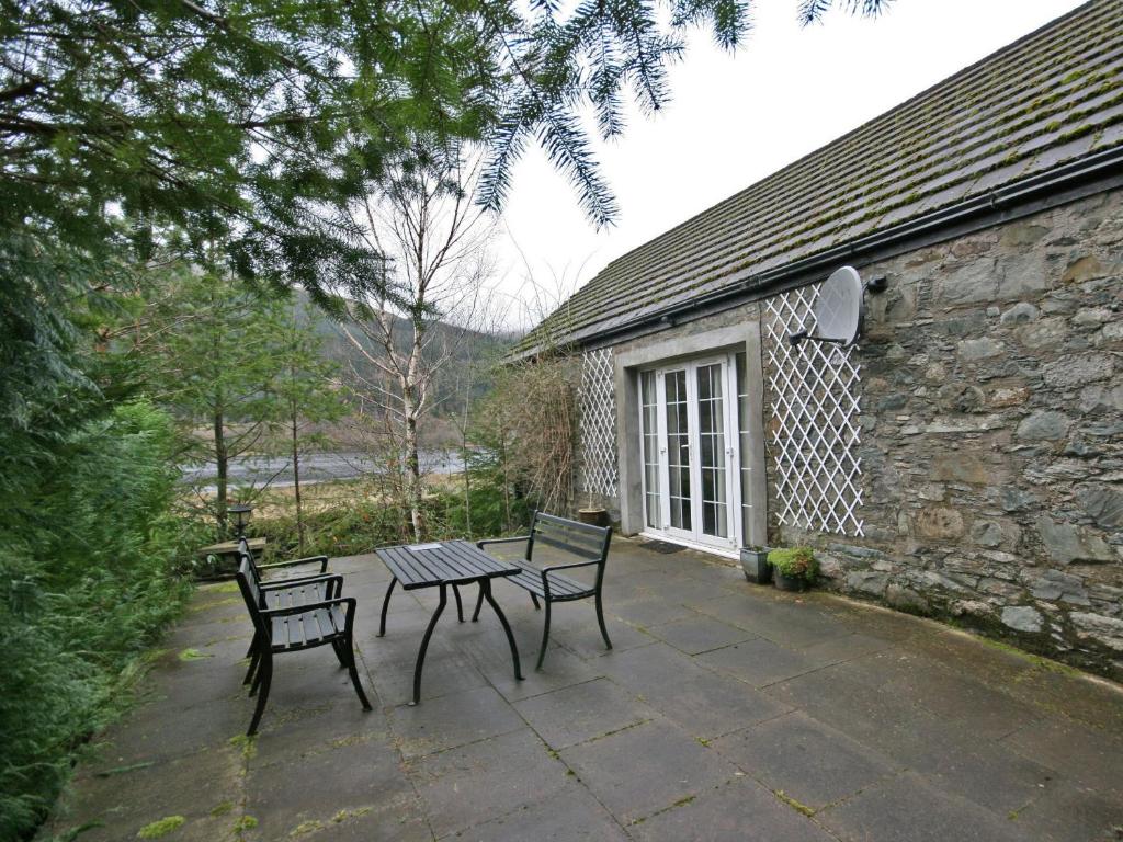 a patio with a table and two chairs and a building at Lochview Barn in Strathyre