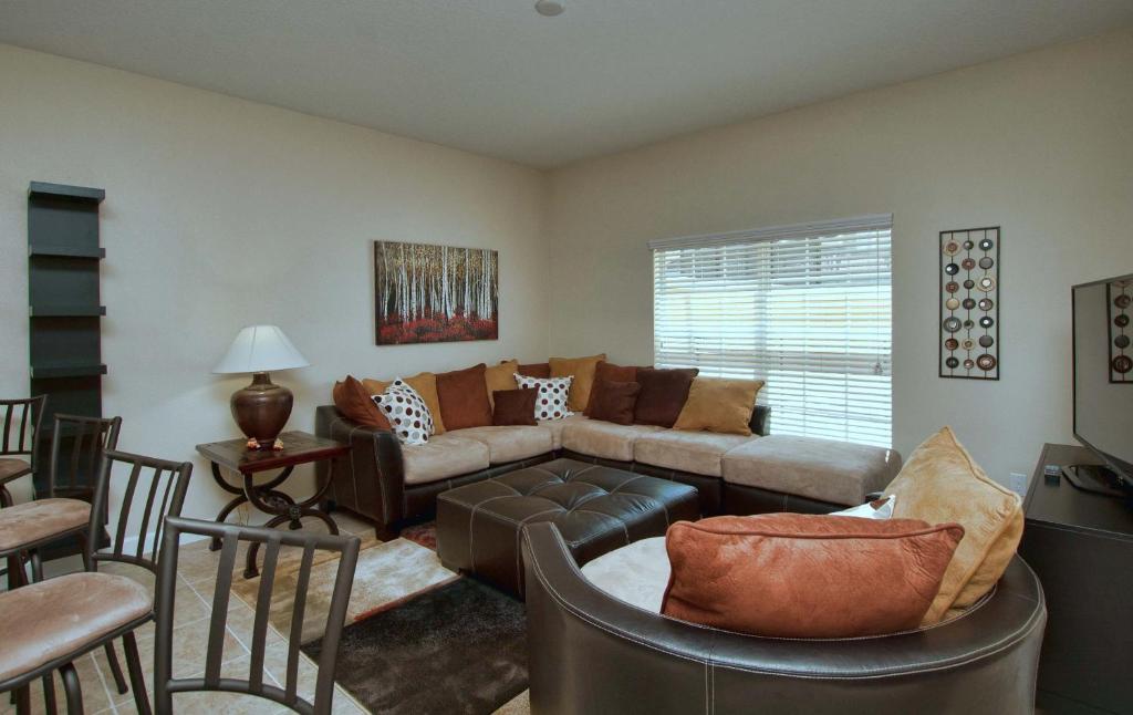 uma sala de estar com um sofá, uma mesa e cadeiras em Paradise Palms 8952 em Kissimmee