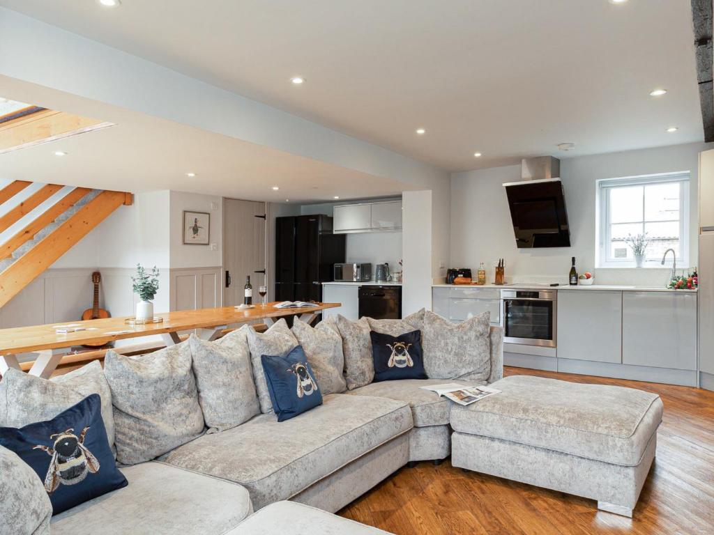 a living room with a couch and a kitchen at Dovecote House-Uk30233 in Cayton