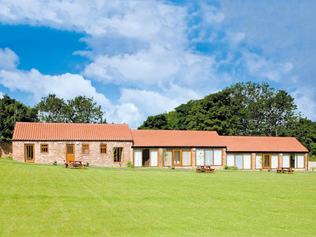 a house with a large grassy field in front at Cobble Cottage - W41945 in Filey
