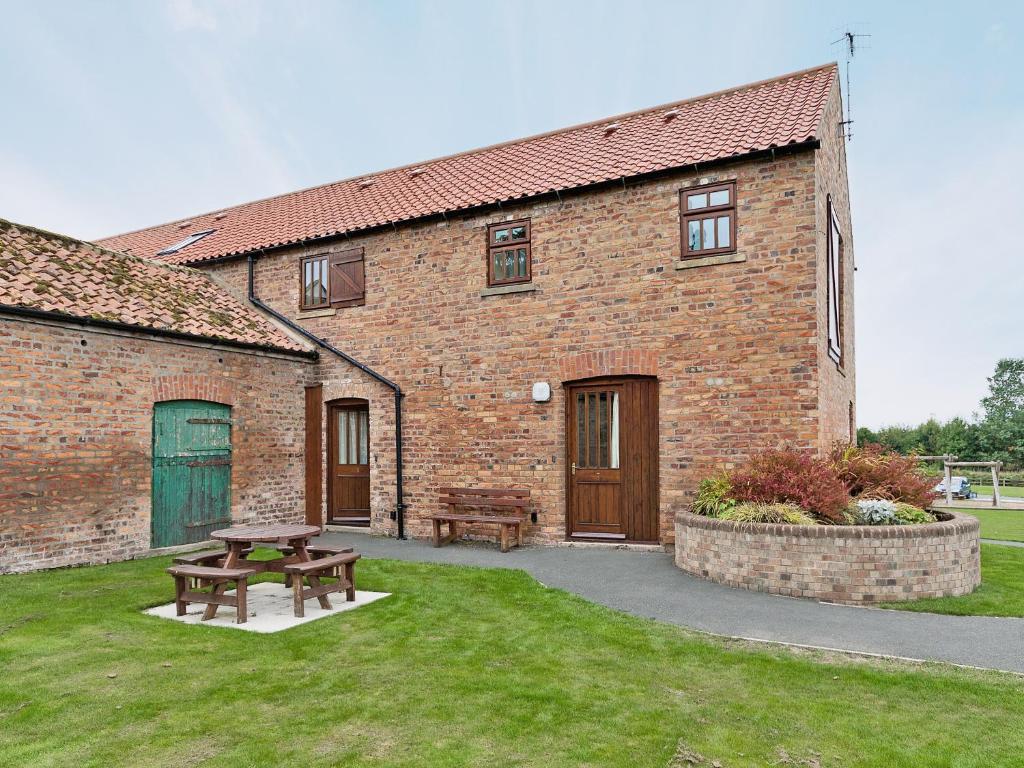 a brick building with a picnic table in the yard at Trueman - W41948 in Filey