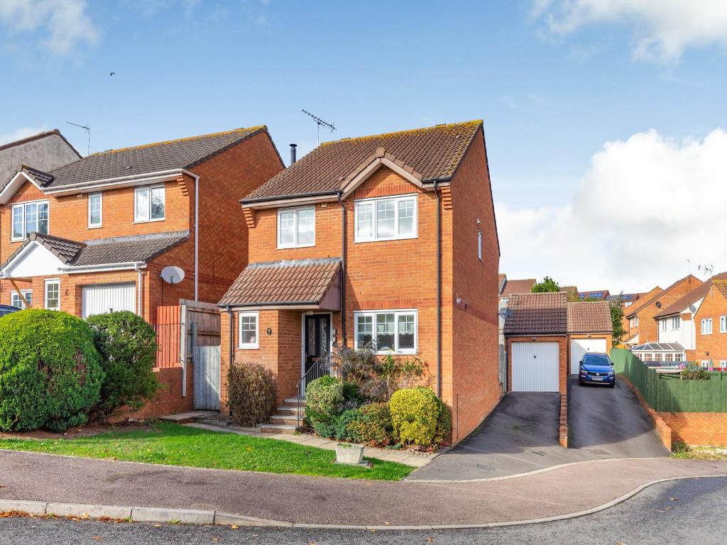 a brick house with a driveway in front of it at Chaucer Rise in Exmouth