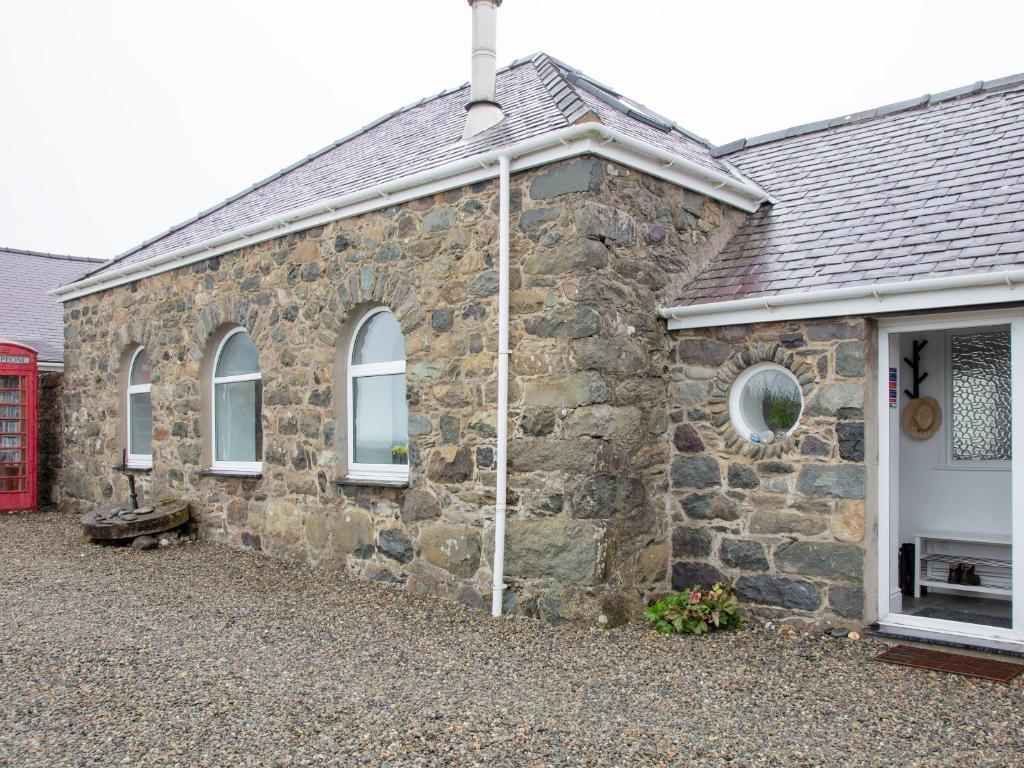 a stone house with a white door and windows at Granary - Ukc4684 in Clynnog-fawr