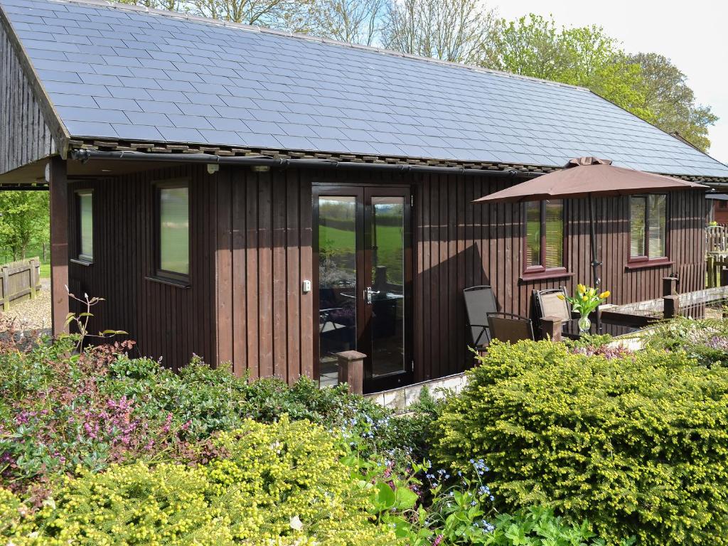 a small house with a black roof at Ash Lodge in Nawton
