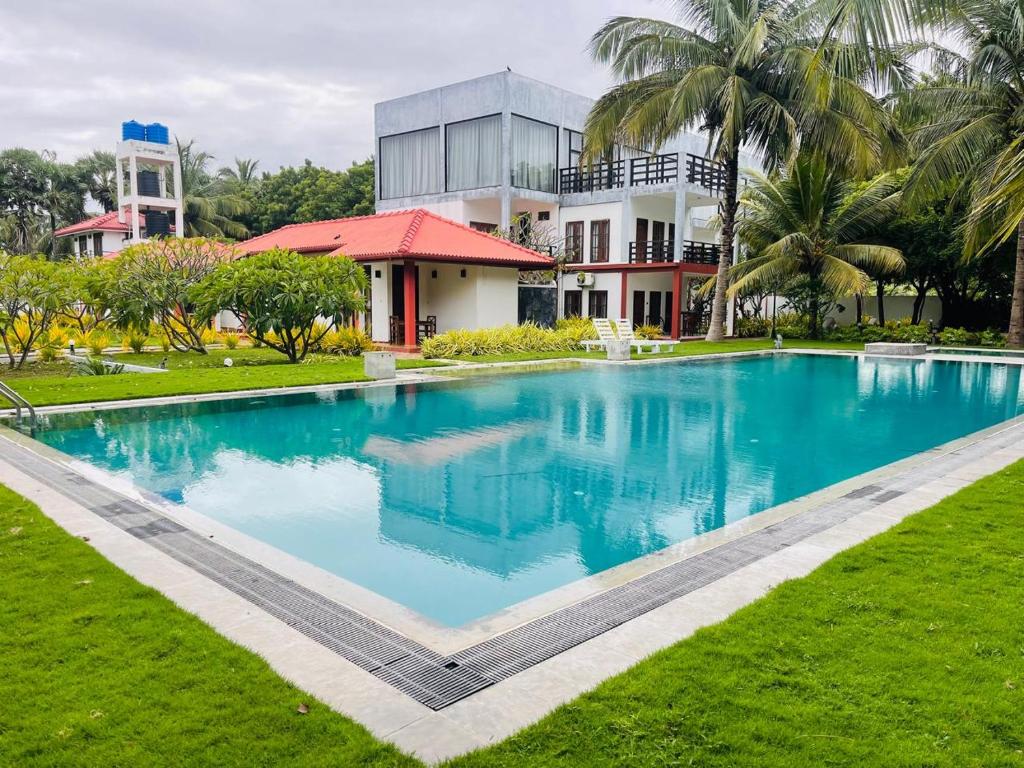 a large blue swimming pool in front of a building at NN Beach Resort Nilaveli in Nilaveli