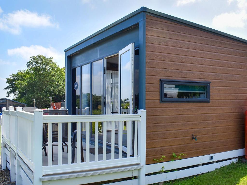 a tiny house with a wooden exterior and a white fence at Valley View - Uk50320 in Liskeard