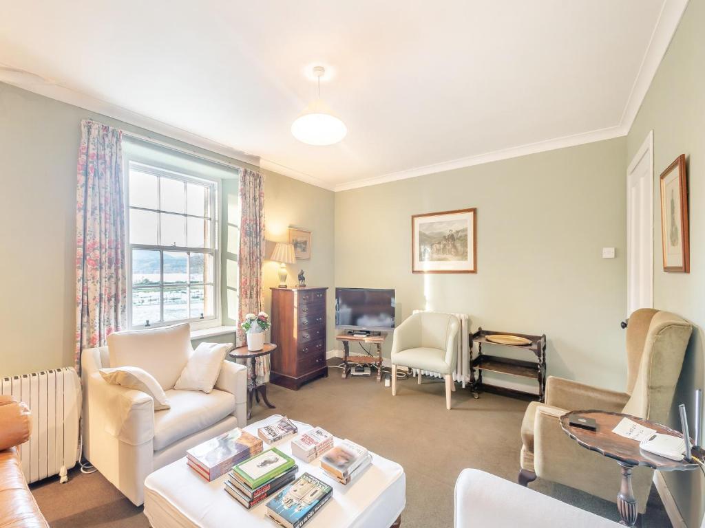 a living room with a couch and a table at Rhoda's Cottage in Strachur