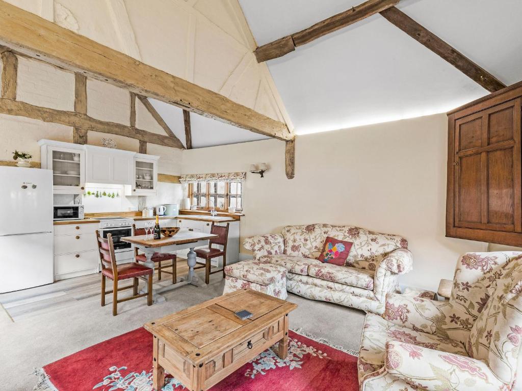 a living room with a couch and a table at Gardeners Cottage in Putley