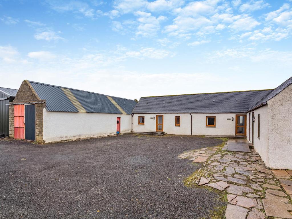 a large white building with a black roof at The Stable Mey in Scarfskerry