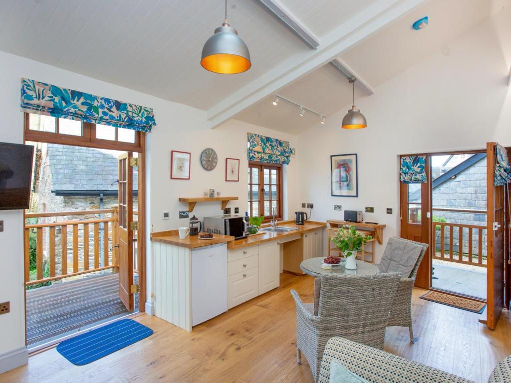 a kitchen and living room with a table and chairs at Mill Balcony in Ashsprington