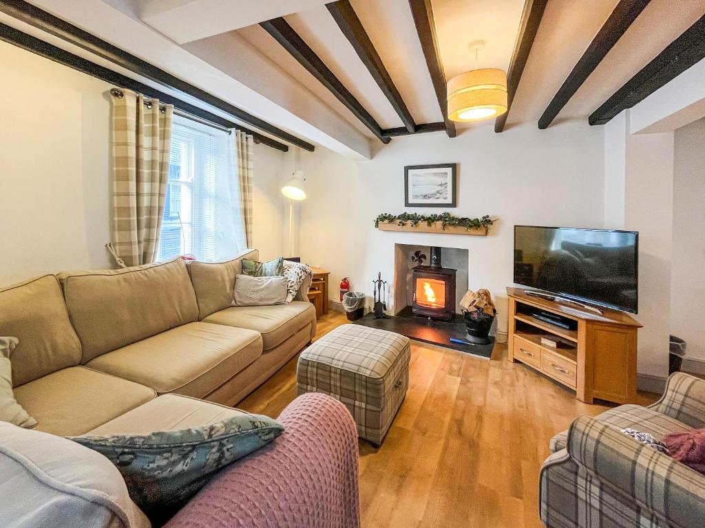a living room with a couch and a flat screen tv at Return Again in Beaumaris