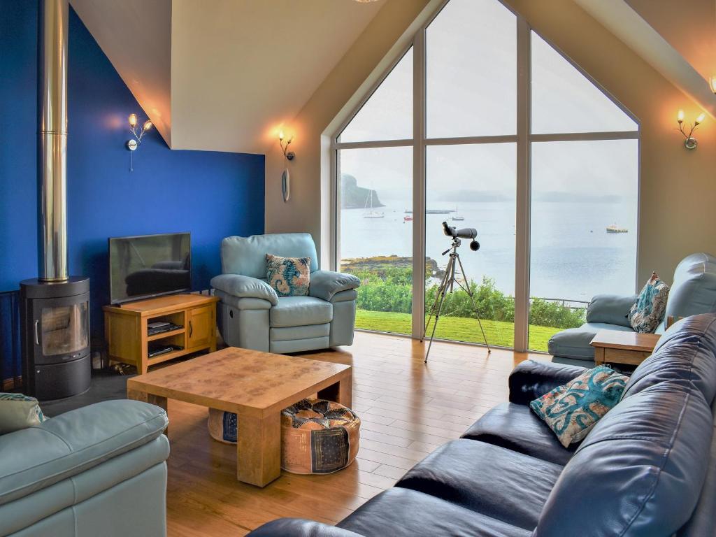 a living room with a couch and chairs and a tv at Shelduck House in Port na Long