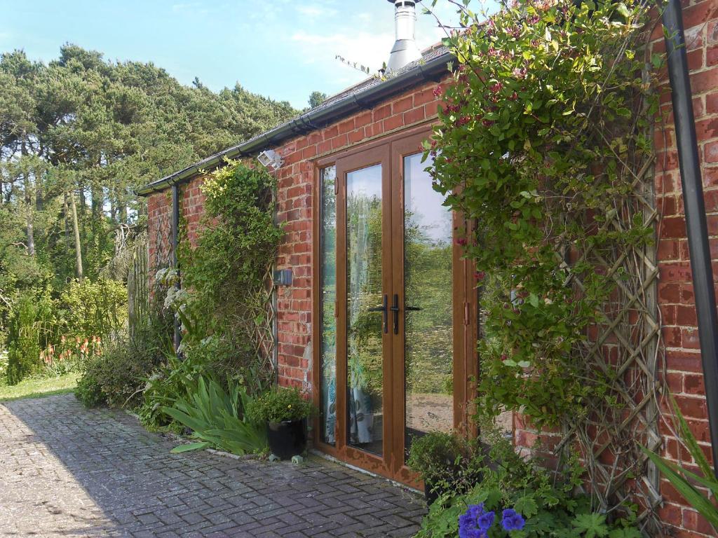 a red brick house with a glass door at Shepherdskirk in Kyloe
