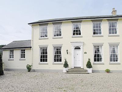 a large white house with a white door at Wold House Cottage in Nafferton