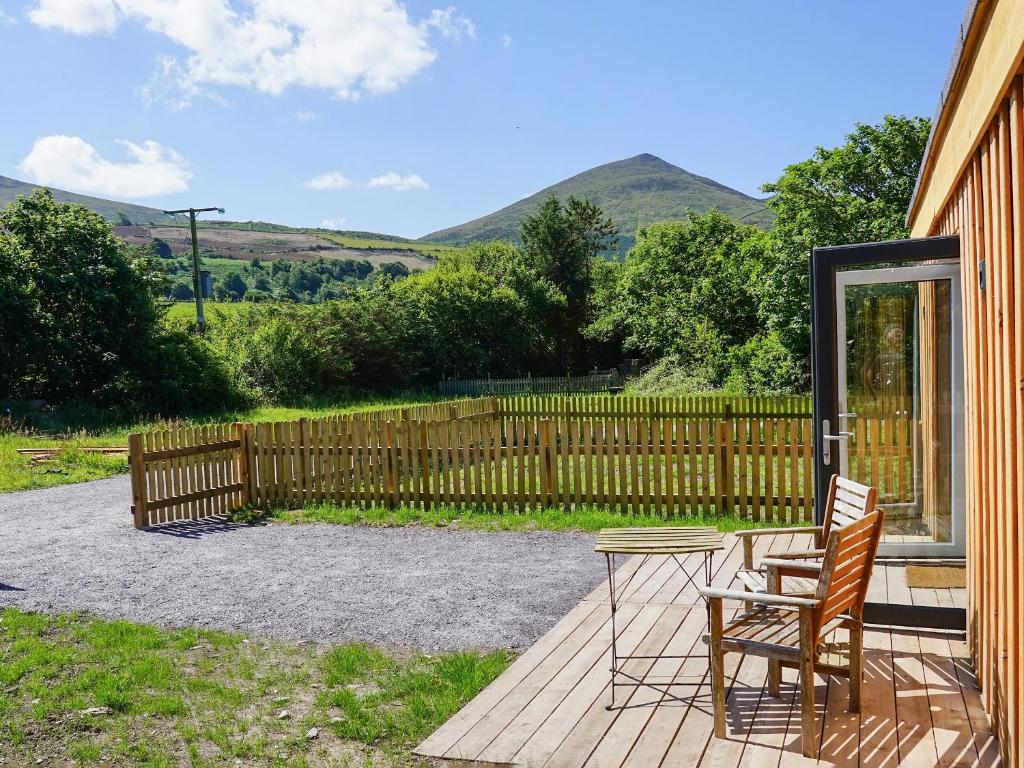 a patio with two chairs and a table and a fence at Bueno - Ukc4682 in Clynnog-fawr
