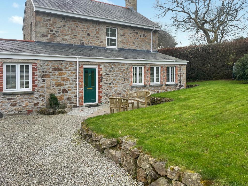a brick house with a green door and a lawn at The Farmhouse - Uk49068 in Liskeard