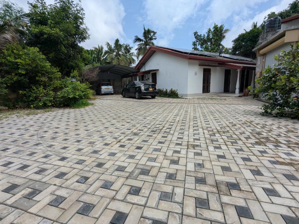 a brick driveway in front of a house at Prince Cottage - Entire Private Cottage in Kesbewa