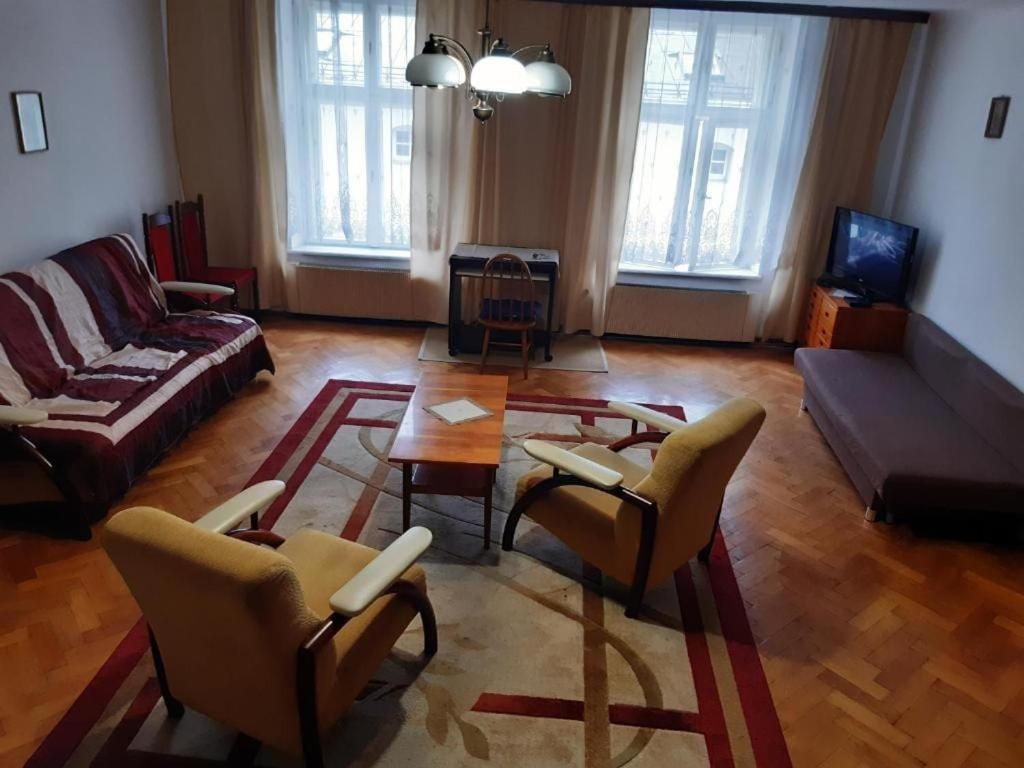 a living room with a couch and a table and chairs at Let's go back to the memories in Krakow