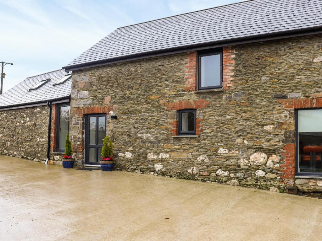a brick building with windows and a driveway at Stables in Carmarthen