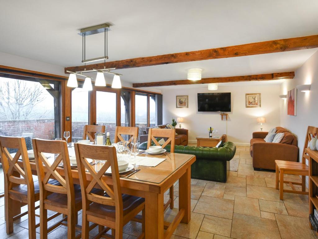 a dining room and living room with a table and chairs at Lower House Barn in Staunton on Wye