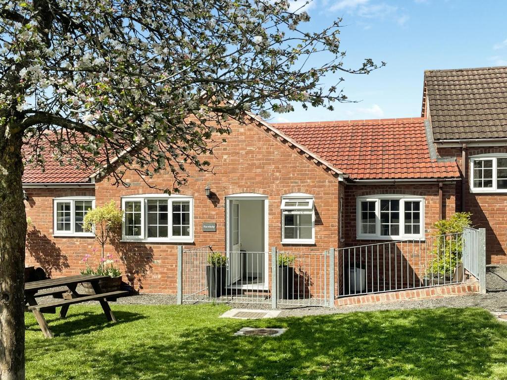a brick house with a bench in front of it at Foxwhelp in Ledbury