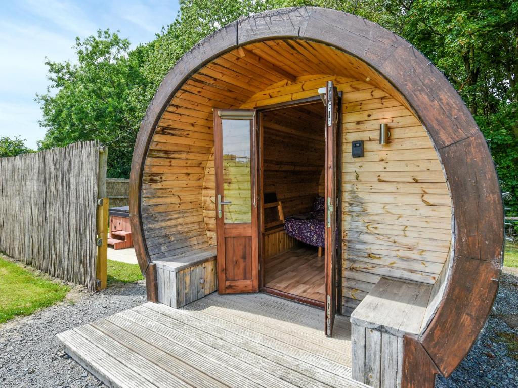 a large wooden hobbit house with a wooden door at Willow - Glamping Pod - Uk49947 in Oswestry
