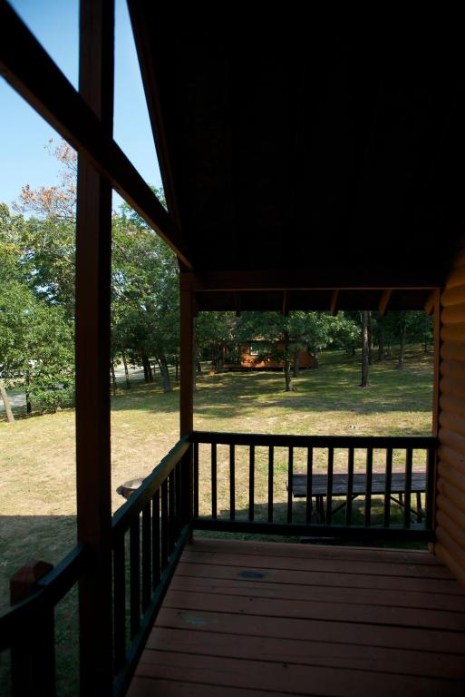 a screened in porch with a view of a park at Arrowhead Camping Resort Loft Cabin 20 in Douglas Center