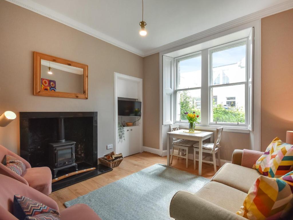 a living room with a fireplace and a table at The Leveret in Aberlady