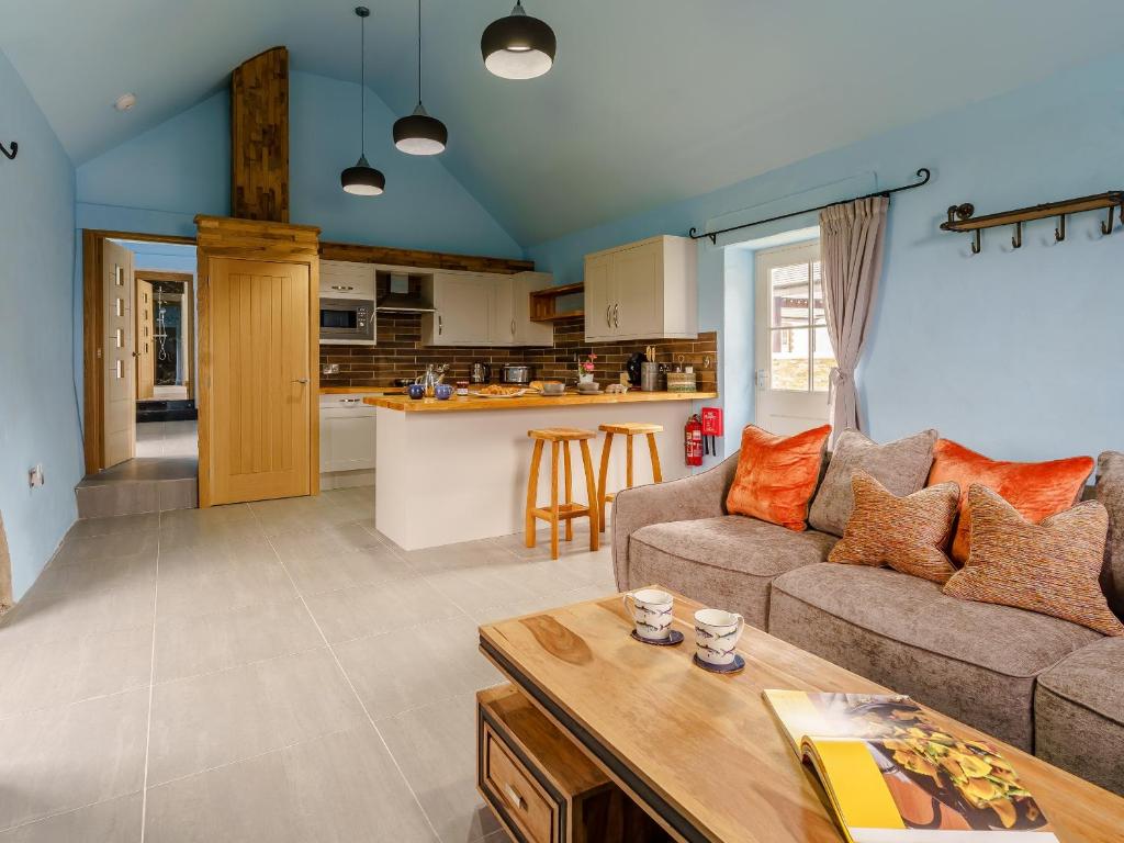 a living room with a couch and a table at The Cowshed - Uk32570 in Marloes