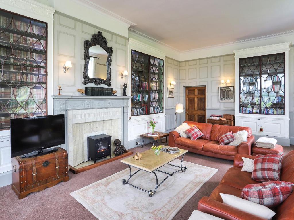 a living room with a couch and a fireplace at Stargazers - Uk3445 in Greenhaugh
