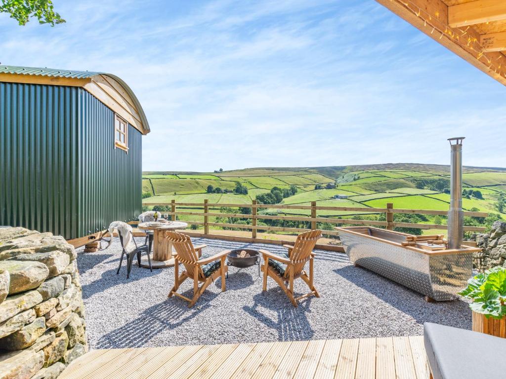 a deck with a boat and a table and chairs at Flossys Hut - Uk43675 in Haworth