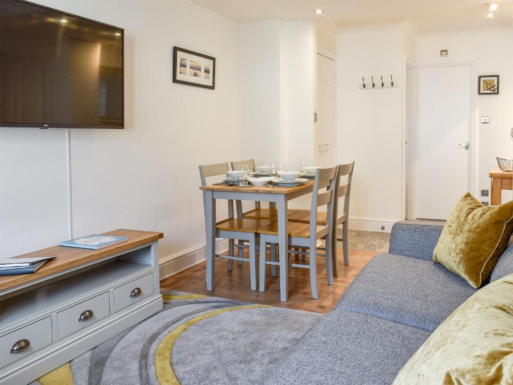 a living room with a couch and a dining room table at The Snug in Bowness-on-Windermere
