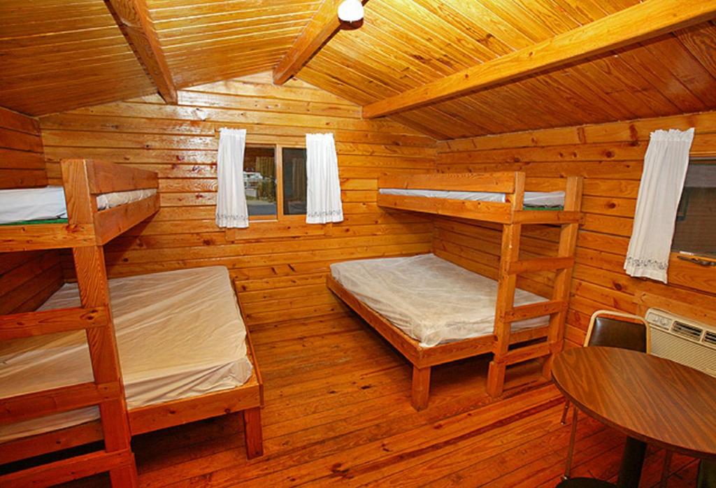 a log cabin with two bunk beds and a table at Arrowhead Camping Resort Cabin 1 in Douglas Center