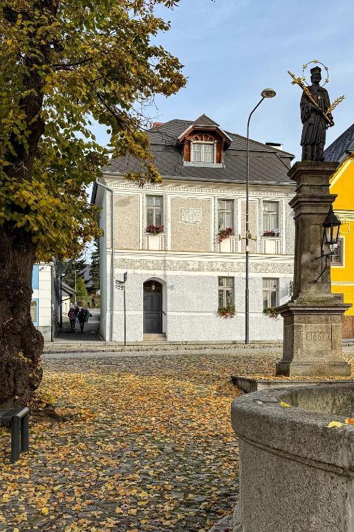 a statue of a man in front of a building at Penzion Nad Kašnou in Kašperské Hory