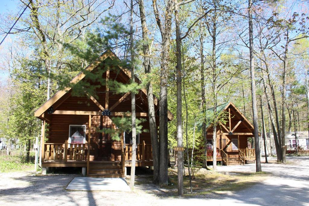 a log cabin in the woods with trees at Tranquil Timbers Deluxe Cabin 6 in Sturgeon Bay