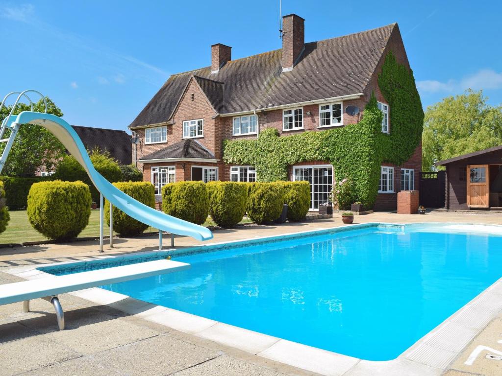 a swimming pool with a slide in front of a house at New Inn House in Harvington
