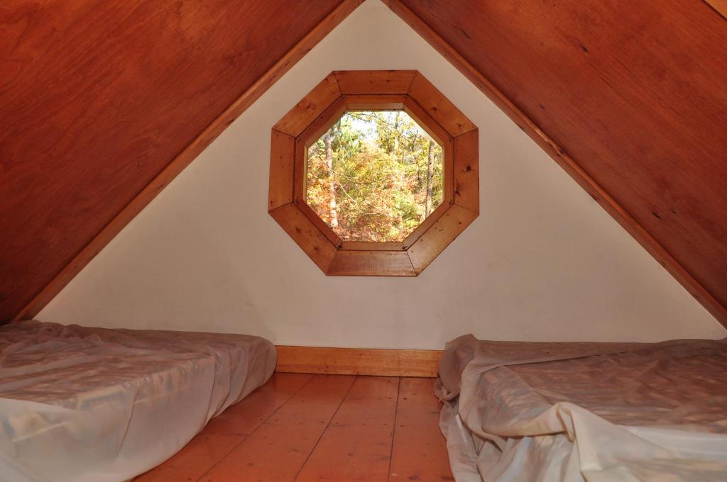 um quarto no sótão com 2 camas e uma janela em Arrowhead Camping Resort Loft Cabin 22 em Douglas Center