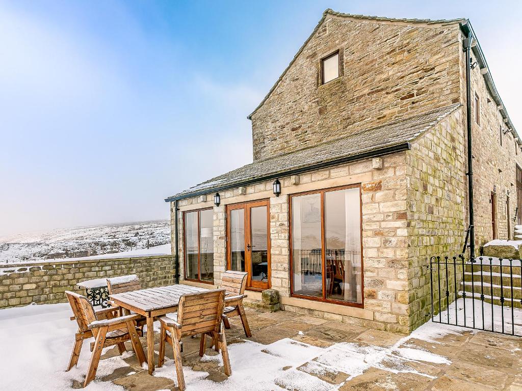 a stone house with a table and chairs at Water's Edge - Uk32390 in Dunford Bridge