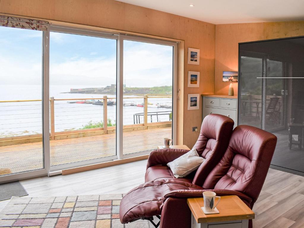 a living room with a couch and a large window at The Duckling in Port na Long