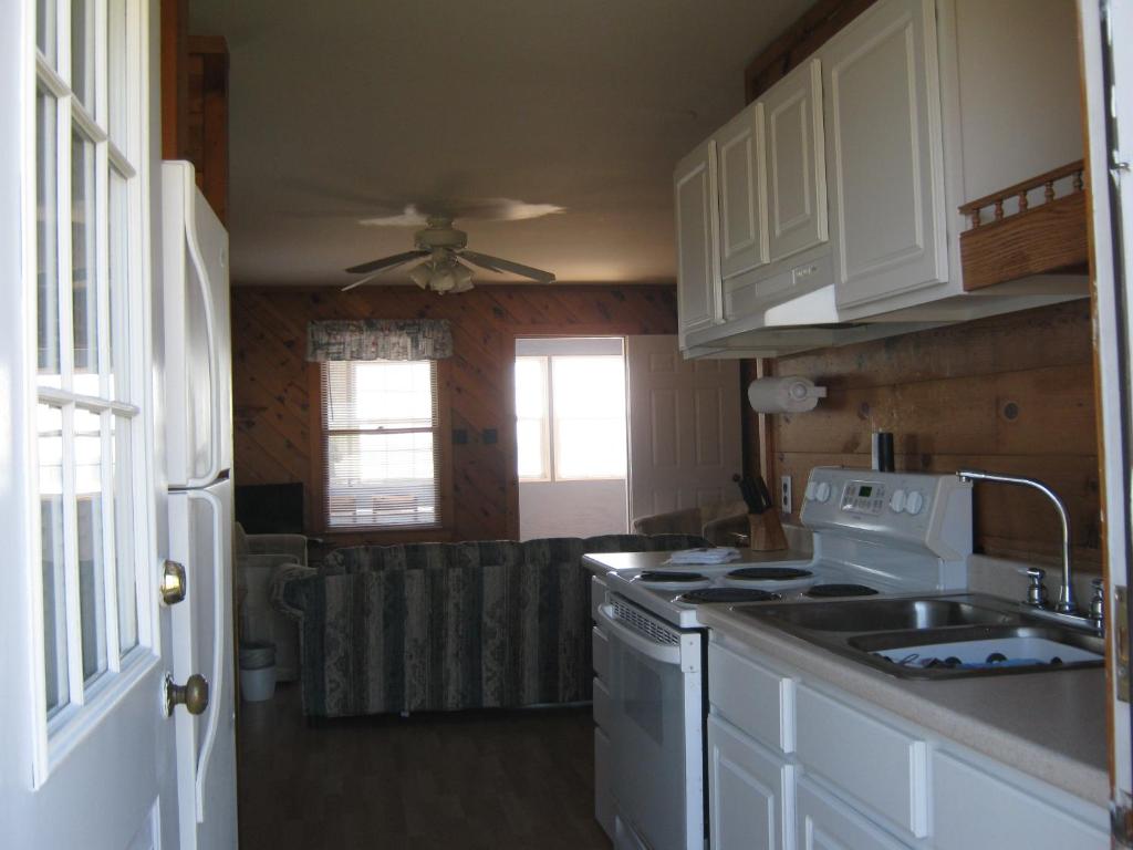 cocina con fregadero y fogones horno superior en Virginia Landing Camping Resort Cabin 19, en Quinby