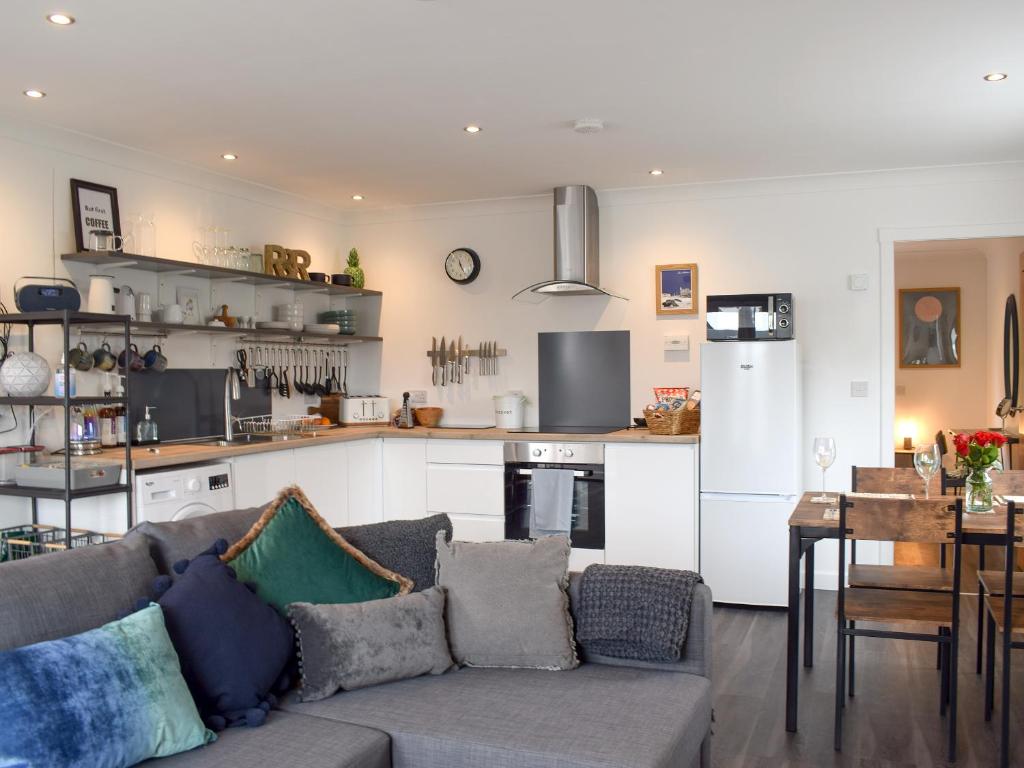 a living room with a couch and a kitchen at The Rest in St. Andrews