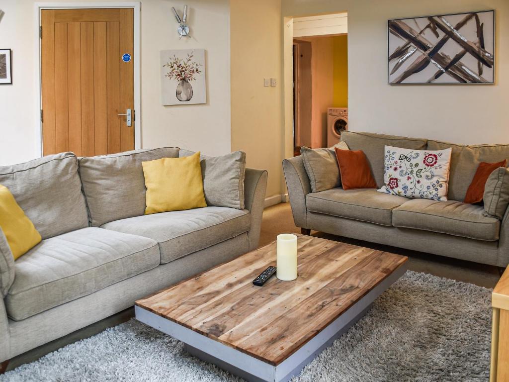 a living room with two couches and a coffee table at The Pool House - Uk48229 in Tibenham