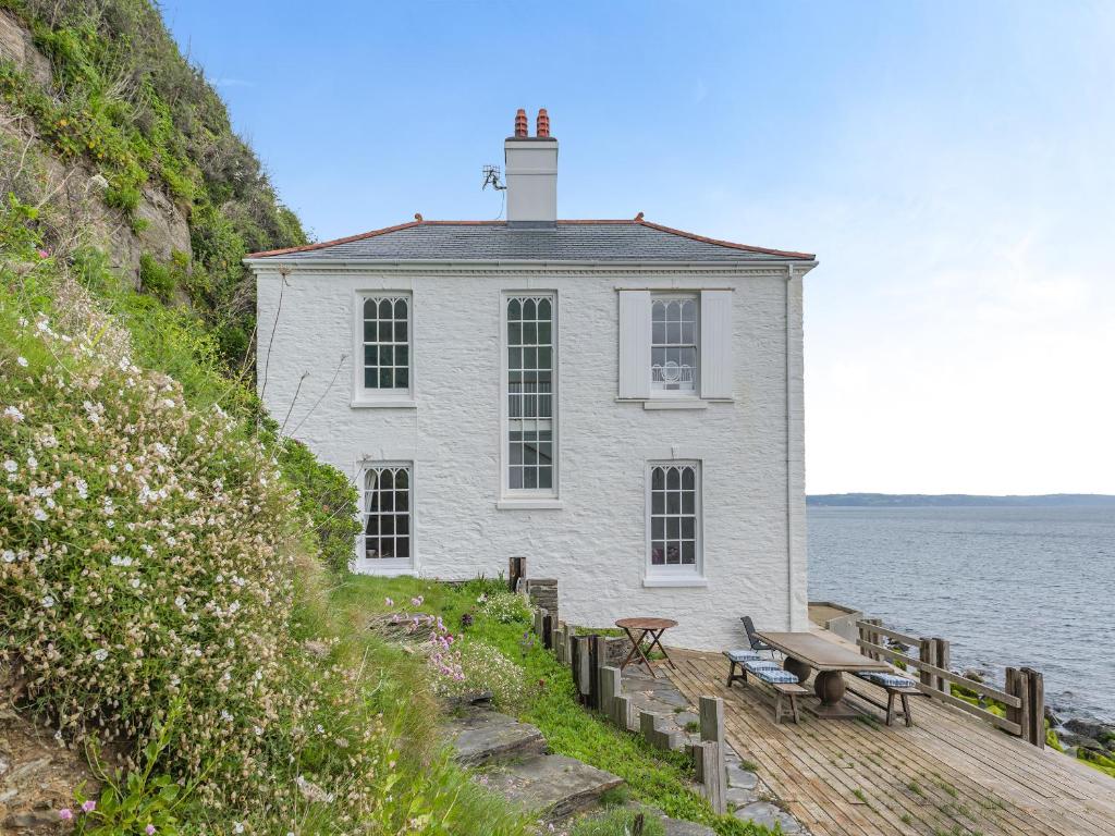 a white building on the side of the water at Cliff House in Beesands