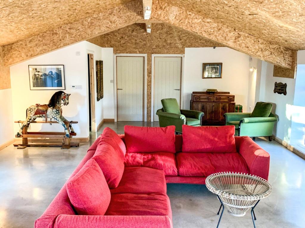 a living room with a red couch and green chairs at The Organic Cabin - Uk42325 in Horsington