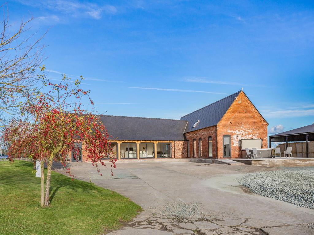 a brick building with a tree in front of it at Buckley Farm, Barn 1 - Uk36588 in Oswestry